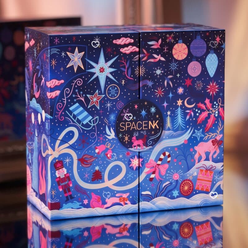 Space NK Adventskalender 2026 mit nachtblauer Illustration: Nussknacker, Rentiere und Sterne