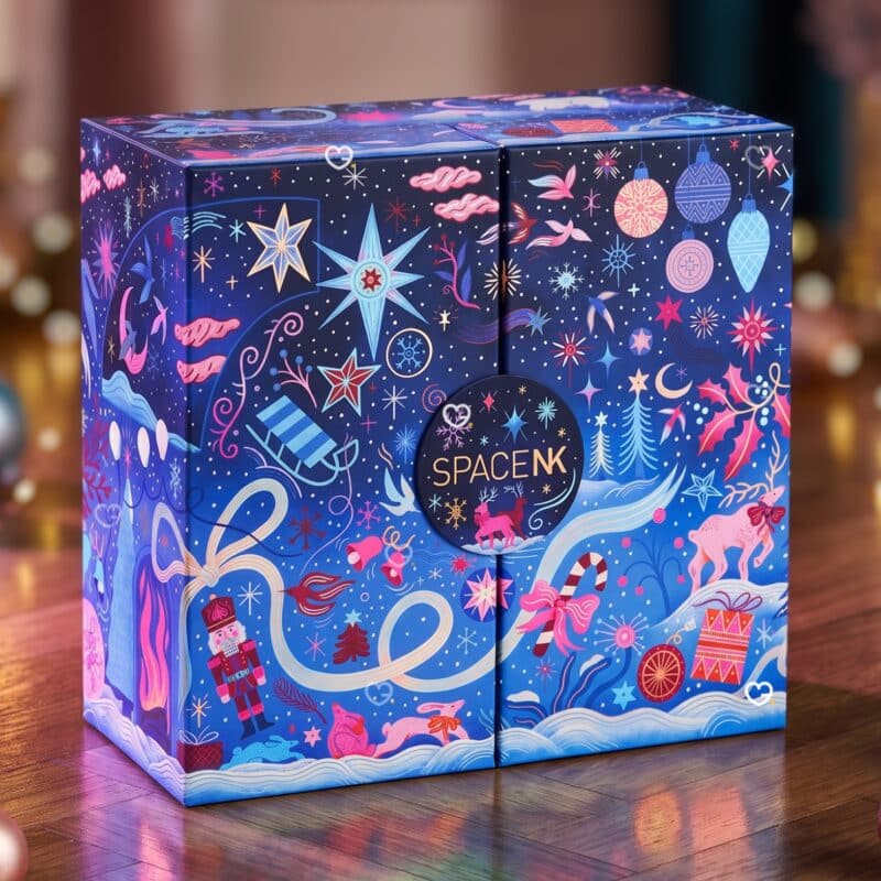 Space NK Beauty-Adventskalender 2026 auf einem Holztisch vor festlichen Lichtern