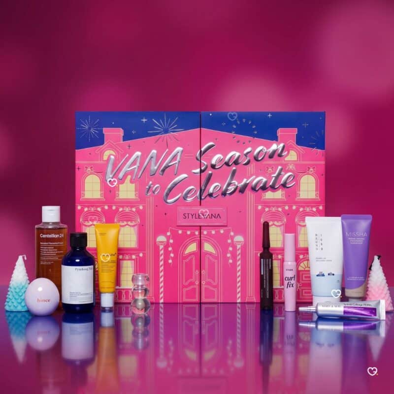 Stylevana Adventskalender 2026 Box mit allen 25 K-Beauty-Produkten aufgefaechert vor magentafarbenem Hintergrund