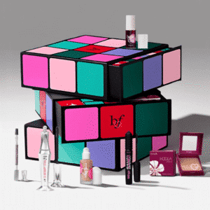 Benefit Adventskalender 2025 mit 24 Beauty-Überraschungen in festlicher Box, Mix aus Bestsellern und Neuheiten.