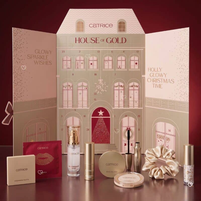 Catrice Adventskalender 2026 geoeffnet mit nummerierten Tuerchen und Make-up-Produkten davor