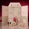 Catrice Adventskalender 2026 geoeffnete Hausbox mit Produkten auf glitzerndem Hintergrund