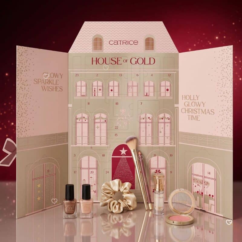 Catrice Adventskalender 2026 geoeffnete Hausbox mit Produkten auf glitzerndem Hintergrund