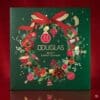 Douglas Beauty Adventskalender 2026 Verpackung vor rotem Hintergrund
