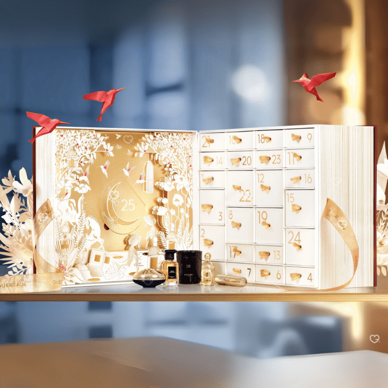 Guerlain Adventskalender 2025 in gold-weißer Box mit 25 Luxusminiaturen aus Parfum, Pflege, Make-up und Duftkerzen.