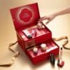 Hand oeffnet ein Tuerchen des Shiseido Adventskalenders 2026 mit zwei Schubladen und goldenem Band