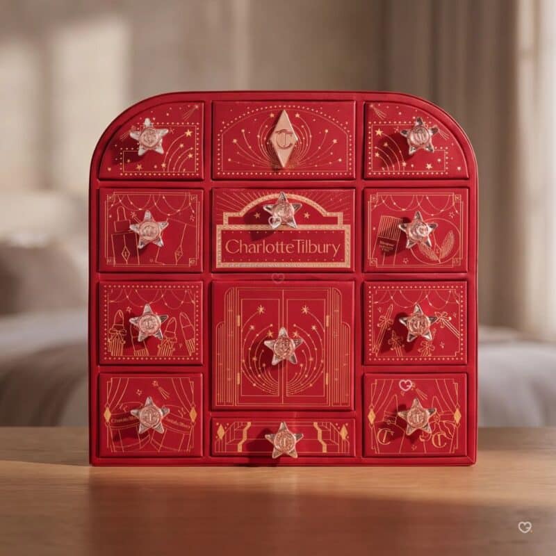 Charlotte Tilbury Adventskalender 2026, rote Beauty-Box mit 12 Türchen auf einem Holztisch