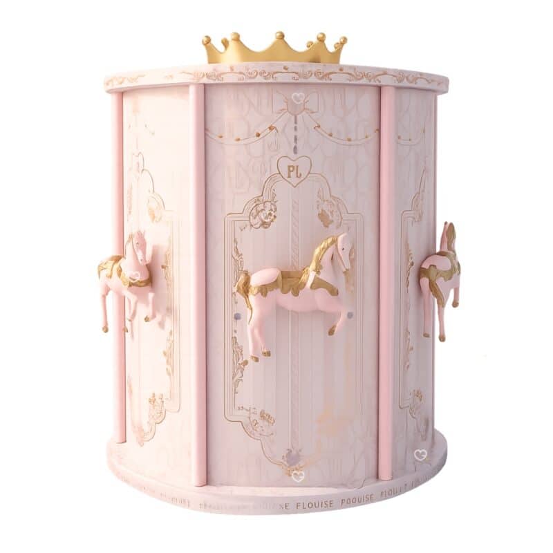 Plouise Adventskalender 2026 „What Glows Around“, beleuchtetes Karussell in Rosa und Gold vor hellem Hintergrund