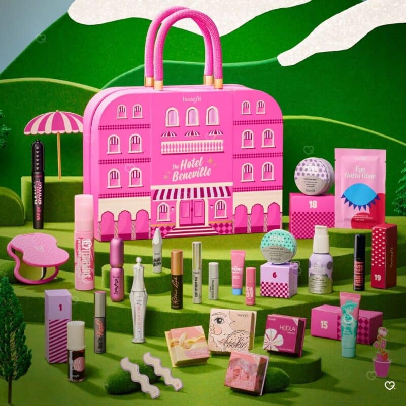Benefit Beauty Adventskalender 2026 Koffer in grüner Gartenkulisse
