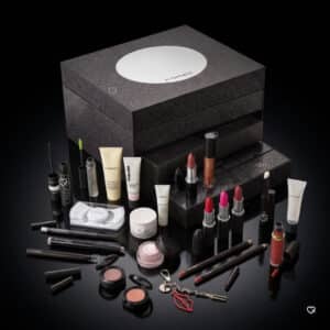 Inhalt des MAC Cosmetics Adventskalender 2026: 24 Make-up- und Pflegeprodukte vor schwarzem Hintergrund