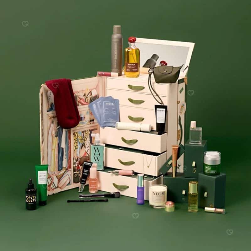 Alle 25 Full-Size-Produkte des Vogue Adventskalender 2026 rund um die Reisetruhe angeordnet