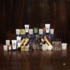 Diptyque Adventskalender 2026, Kerzen und Pflegeprodukte auf dunklem Holz