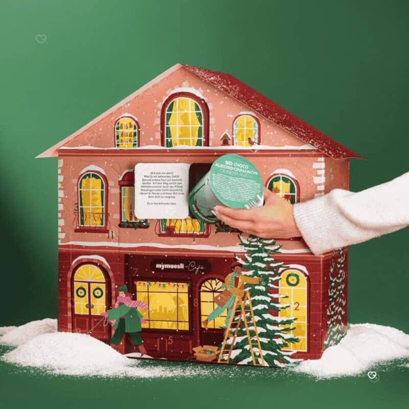 Hand entnimmt einen 2go-Becher aus dem mymuesli Adventskalender