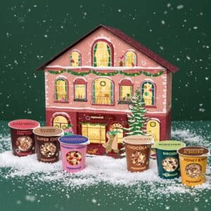 mymuesli Adventskalender mit mehreren 2go-Bechern vor dem verschneiten Haus