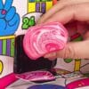 Hand zieht ein Mini-Squishy Candy Cane aus einem Türchen des NeeDoh Adventskalenders 2026
