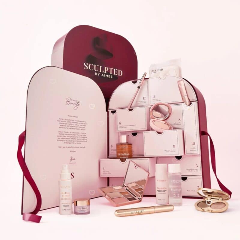 Sculpted By Aimee Beauty Adventskalender 2026 geöffnet, alle 12 Produkte auf rosa Hintergrund