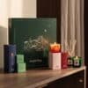 Ava & May Adventskalender 2026 mit brennender Duftkerze und Mini-Diffuser auf einer Kommode
