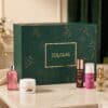 Douglas Luxury Adventskalender 2026 geschlossene Box mit einigen Beauty-Produkten im Hintergrund
