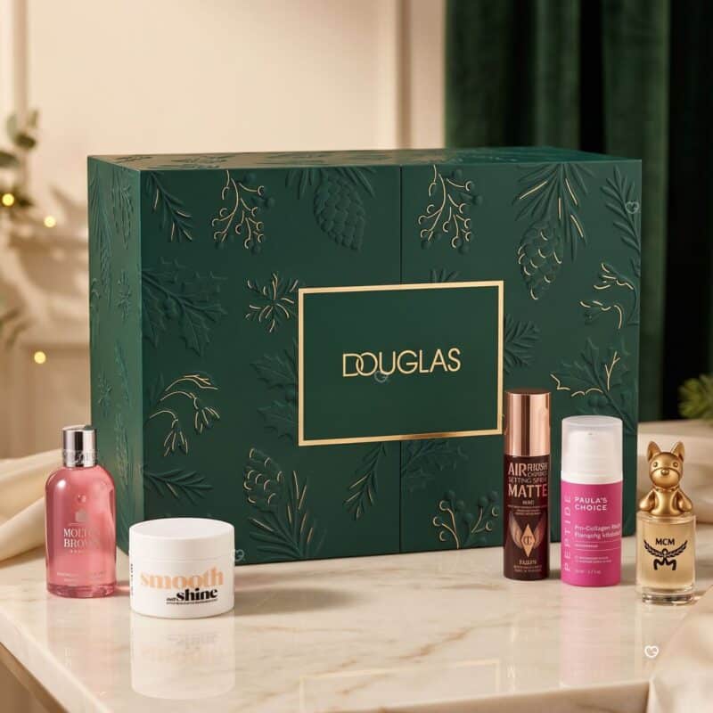 Douglas Luxury Adventskalender 2026 geschlossene Box mit einigen Beauty-Produkten im Hintergrund