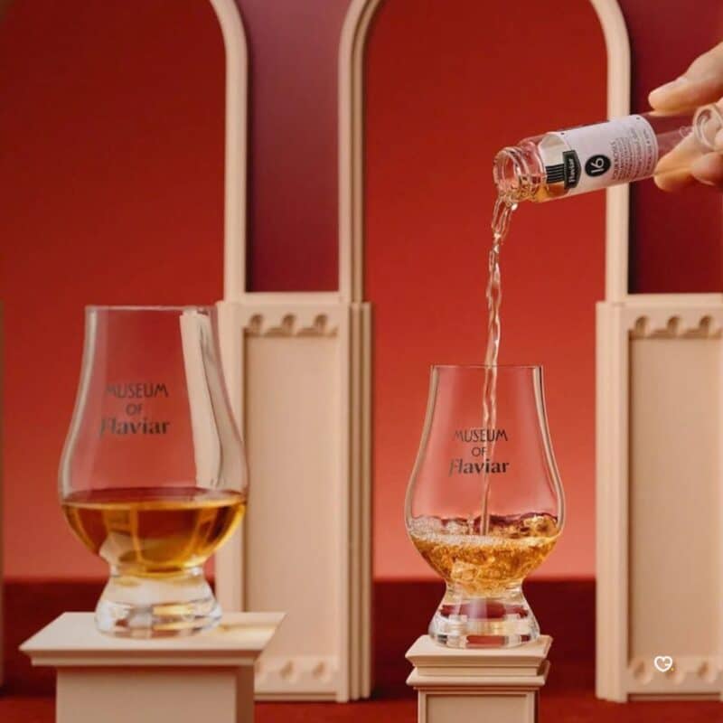 Flaviar Adventskalender 2026, Einschenken einer Probe in ein Glencairn-Glas vor roten Bögen
