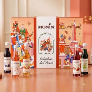 Monin Adventskalender 2026 mit fünf Sirup-Miniaturen vor der Geschenkbox