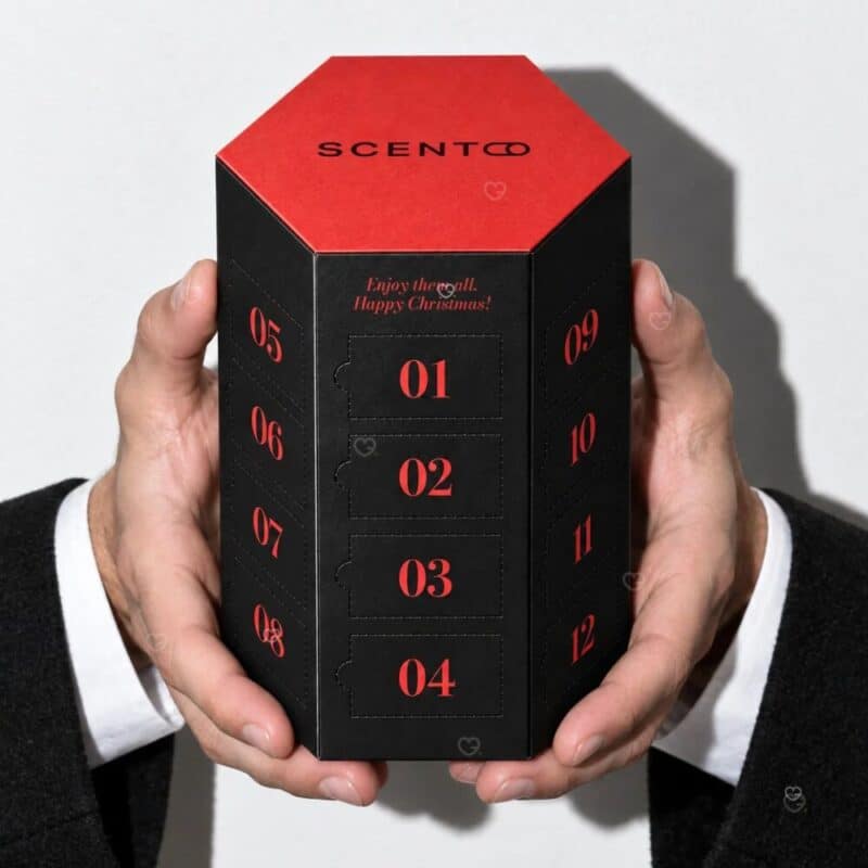 Scento Adventskalender 2026 Geschenkformat in zwei Händen gehalten vor weißem Hintergrund
