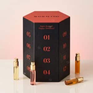 Scento Parfum-Adventskalender 2026 Schachtel mit fünf goldenen Zerstäubern vor rosa Hintergrund