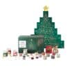 Arrangierter Inhalt des Yankee Candle Baum Adventskalenders 2026 mit Sammlerkugel