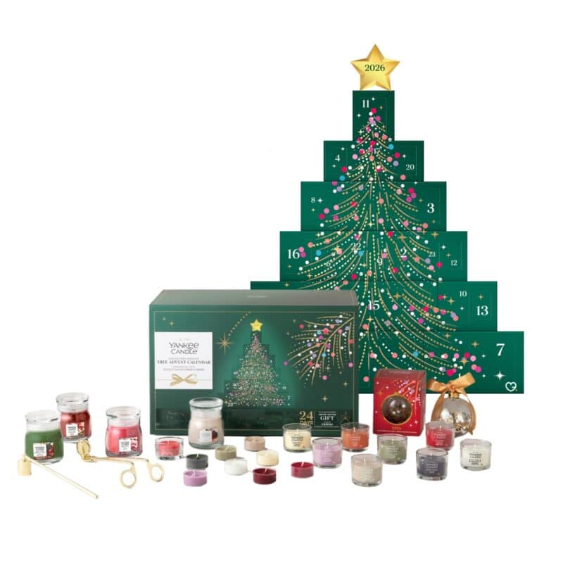 Arrangierter Inhalt des Yankee Candle Baum Adventskalenders 2026 mit Sammlerkugel